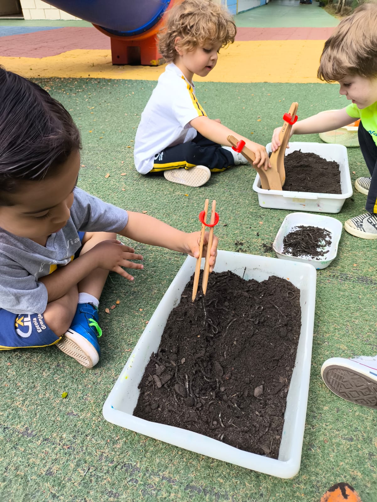 Crianças explorando a terra e minhocas